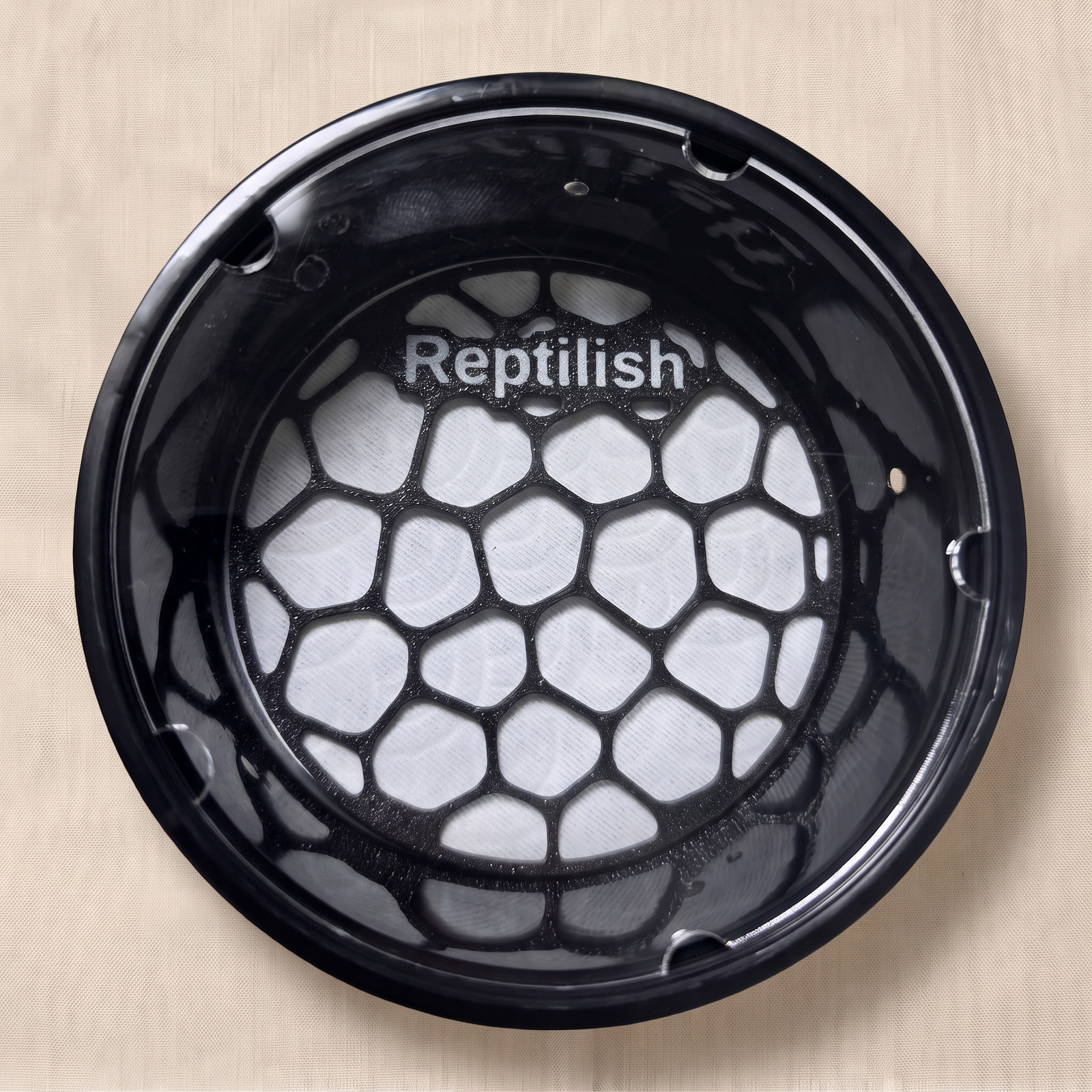 Okrągły pojemnik z pokrywą akrylową widziany z góry, w środku płytka Pebble Plate w kolorze Carbon Black