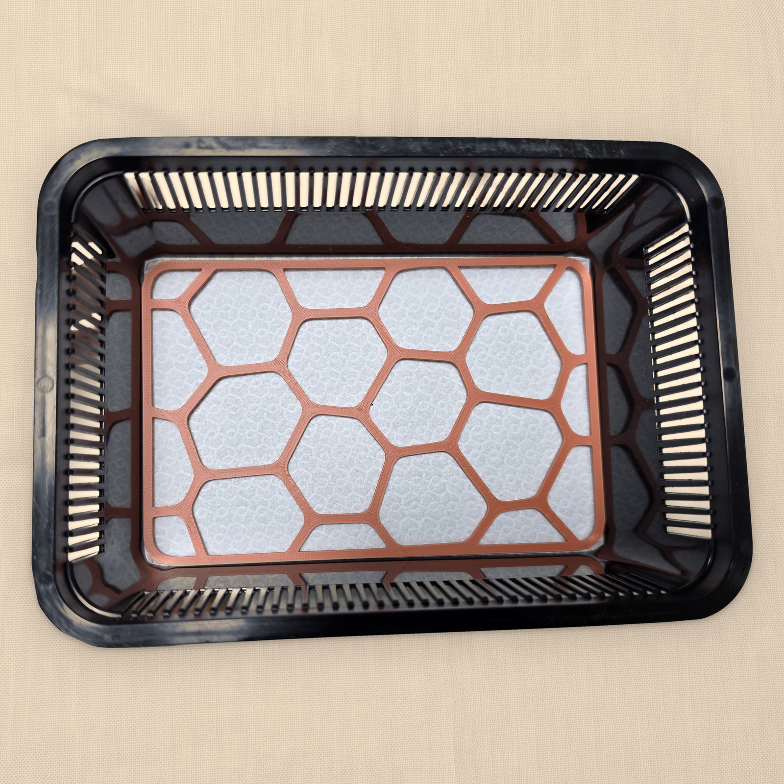 Prostokątna płytka Pebble Plate w kolorze Terracotta bez graweru, leżąca na macie w małym faunarium
